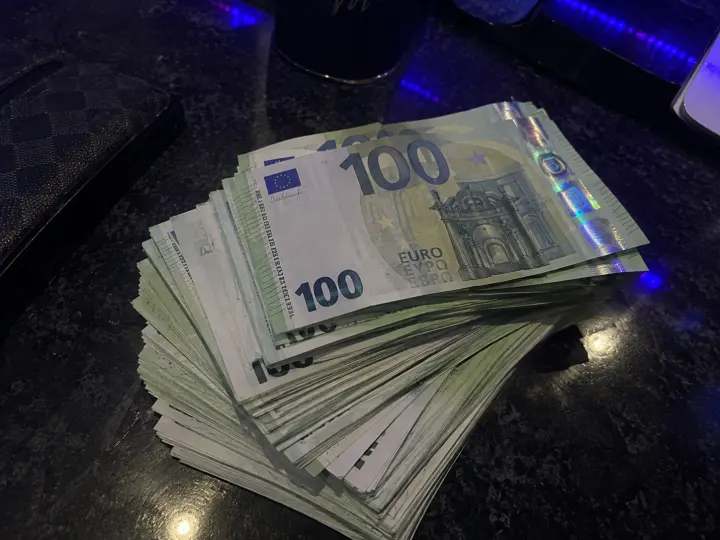 Stacks of €100 fake money under blue light